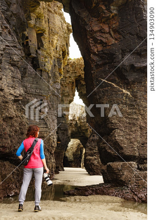 Woman with camera at Cathedral Beach, Galicia Spain. Woman with camera at Cathedral Beach, Galicia Spain. 134903090