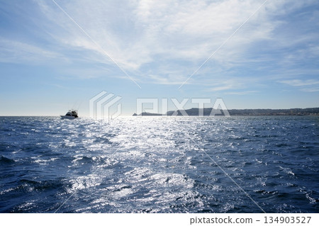 Blue Mediterranean sea with fishing boat far in horizon 134903527