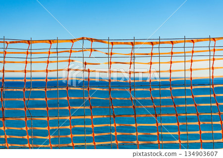 Volleyball net against blue sea water Volleyball net against blue sea water 134903607