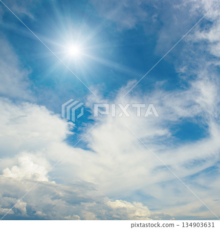 Atmospheric sky view with sunlight radiating outward and clouds drifting across open space in vibrant daylight Atmospheric sky view with sunlight radiating outward and clouds drifting across open space in vibrant daylight 134903631