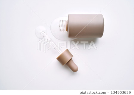 Skincare product packaging with spilled serum and pipette Skincare product packaging with spilled serum and pipette 134903639
