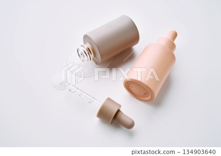 Cosmetic serum bottles with pipette dropper distributing liquid 134903640