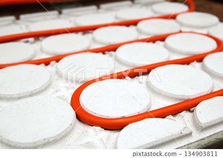 radiant floor heating tube red pipe curved circle pattern 134903811