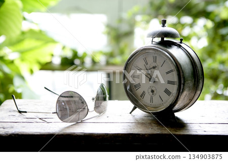 Old alarm bell clock at the window backlit 134903875