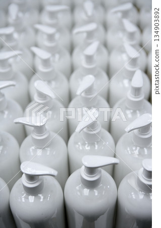 White plastic soap bottles in rows assembly line 134903892