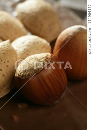 Almond, hazelnuts over chocolate, delicious golden food 134904152