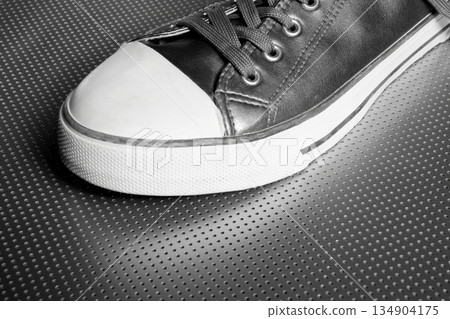 Silver sport shoe detail over gray steel Silver sport shoe detail over gray steel 134904175