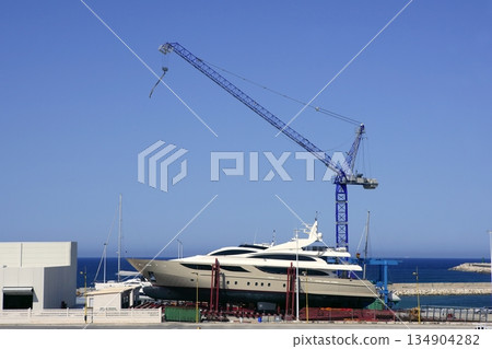 Beached boat with crane on storage area Beached boat with crane on storage area 134904282