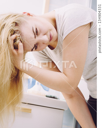 Female having problem with blonde hair 134904331