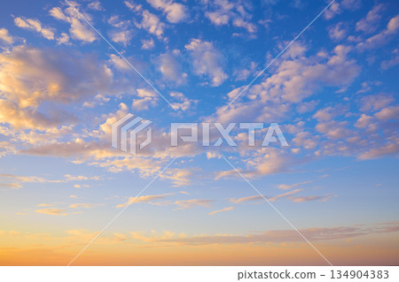 Sunset sky with golden and blue clouds Sunset sky with golden and blue clouds 134904383