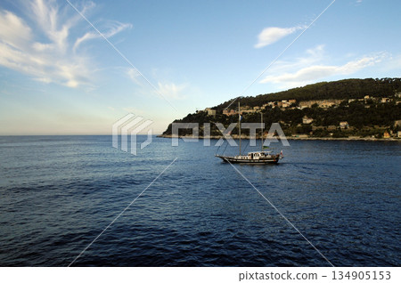 sailboat sailing along the coast on a sunny day sailboat sailing along the coast on a sunny day 134905153