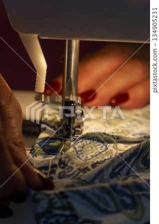woman sewing by machine, close-up sewing tasks 134905231