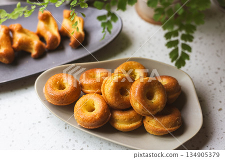 Golden mini donut-shaped pound cake on an oval plate Golden mini donut-shaped pound cake on an oval plate 134905379