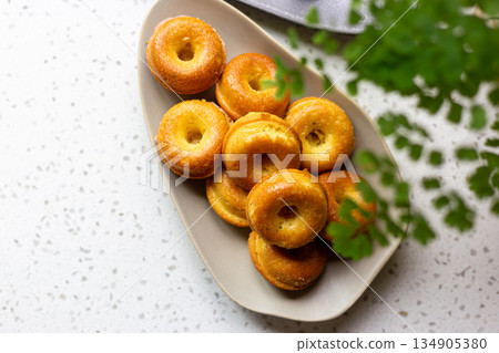 橢圓盤上的金黃迷你甜甜圈造型磅蛋糕 134905380