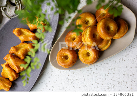 橢圓盤上的金黃迷你甜甜圈造型磅蛋糕 橢圓盤上的金黃迷你甜甜圈造型磅蛋糕 134905381