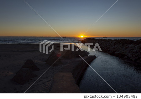 stone pyramids at the mouth of the river by the sea, sunrise image 134905482