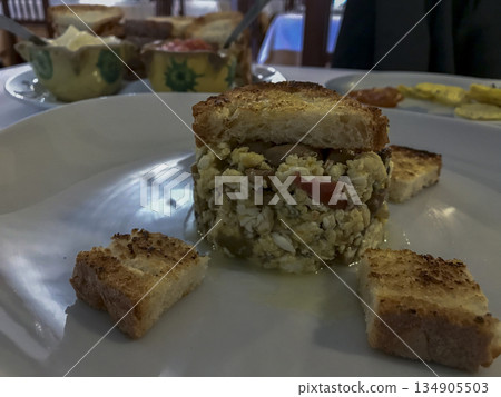 plate of mushroom scrambled eggs with slices of toasted bread, on a white plate at a restaurant table plate of mushroom scrambled eggs with slices of toasted bread, on a white plate at a restaurant table 134905503