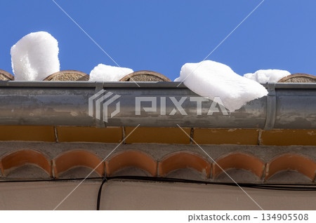 snow on the roof and the metal water channel snow on the roof and the metal water channel 134905508