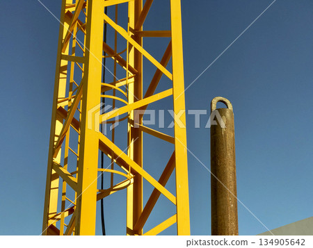 metal structure of a metallic construction site jib crane and the blue sky in the background metal structure of a metallic construction site jib crane and the blue sky in the background 134905642