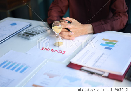 Businessman working on office desk with deadline document and running sand clock. Time management concept. 134905942
