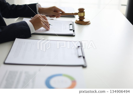 Legal counsel reading contract paperwork to finalize a legal agreement. Concepts for legal counsel, judicial authority, and the finality of a decision or agreement. 134906494