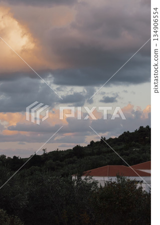 dramatic sunset sky over olive groves and residential buildings in the mediterranean landscape dramatic sunset sky over olive groves and residential buildings in the mediterranean landscape 134906554