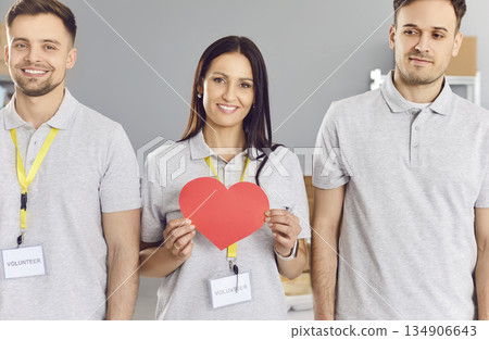 Volunteering people holding red heart, symbol of love, young friends, active volunteering team 134906643