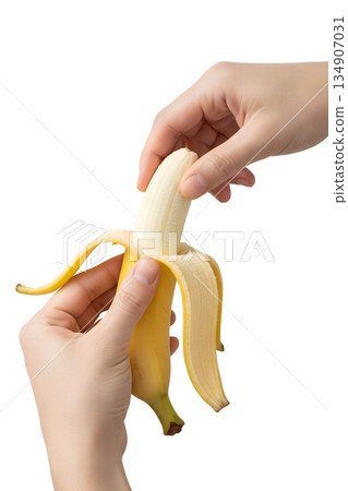 Hands peeling ripe yellow banana, isolated. Simple, healthy food image for snacks, diets, and nutrition themes 134907031