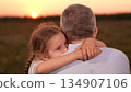 child girl kid childhood outdoors, father man parent male, Father and daughter hug at sunset, Emotional family moment in nature, Girl hugging her dad outdoors, Close bond between parent and child 134907106