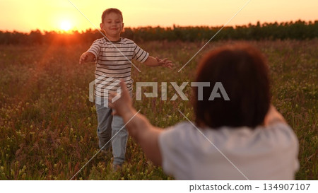 Mother son reunion sunset, Happy child running embrace parent, Family love nature dusk, Warm sunset hug meadow, Joyful boy with open arms, Mother waiting child embrace, Golden hour family moment Mother son reunion sunset, Happy child running embrace parent, Family love nature dusk, Warm sunset hug meadow, Joyful boy with open arms, Mother waiting child embrace, Golden hour family moment 134907107