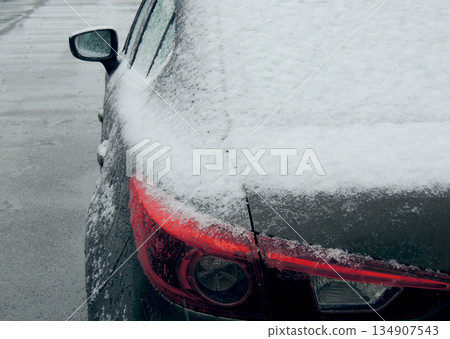 Snow cover the rear lights of the car on the frozen road  134907543