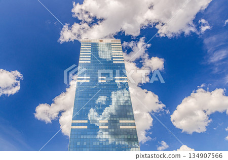 South Tower skyscraper modernism architecture style, modern high-rise office building, abstract details of facade glass curtain wall cells reflecting white clouds in blue sky, Brussels city, Belgium South Tower skyscraper modernism architecture style, modern high-rise office building, abstract details of facade glass curtain wall cells reflecting white clouds in blue sky, Brussels city, Belgium 134907566