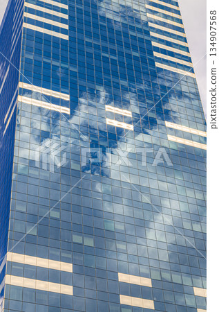 South Tower skyscraper modernism architecture style, modern high-rise office building, abstract details of facade glass curtain wall cells reflecting white clouds in blue sky, Brussels city, Belgium South Tower skyscraper modernism architecture style, modern high-rise office building, abstract details of facade glass curtain wall cells reflecting white clouds in blue sky, Brussels city, Belgium 134907568