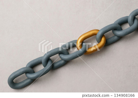 A golden link in a gray chain made of plasticine. Space for text. A golden link in a gray chain made of plasticine. Space for text. 134908166