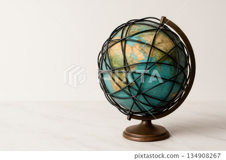 Globe in a metal cage with intertwined lines. Space for text. Globe in a metal cage with intertwined lines. Space for text. 134908267
