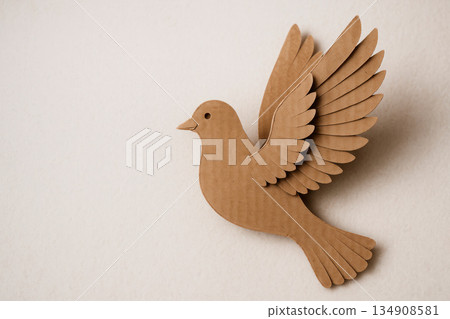A cardboard pigeon with spread wings on a light background. Space for text. 134908581