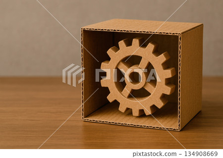 Cardboard gear inside an open box on a wooden table. Space for text. Cardboard gear inside an open box on a wooden table. Space for text. 134908669