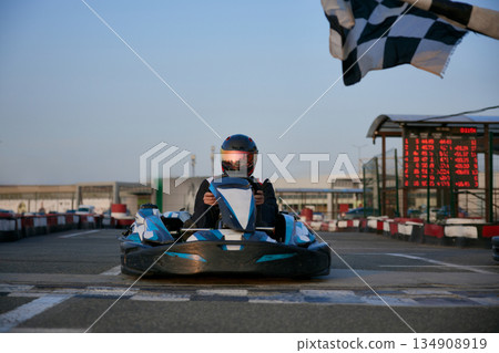 A go-kart racer prepares to hit the track as sunset casts a warm glow. 134908919