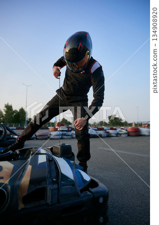 Go-kart racing scene with a racer preparing to take off on a kart track 134908920