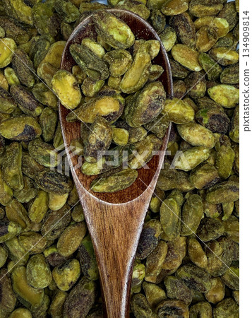 Wooden Spoon Filled with Pistachios - Macro Close-Up of Healthy Nut Snack Wooden Spoon Filled with Pistachios - Macro Close-Up of Healthy Nut Snack 134909814