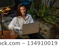 Smiling businesswoman using laptop in luxury hotel 134910019