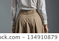 A woman in a white blouse and beige skirt 134910879