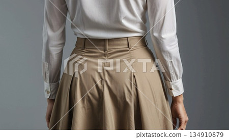 A woman in a white blouse and beige skirt 134910879
