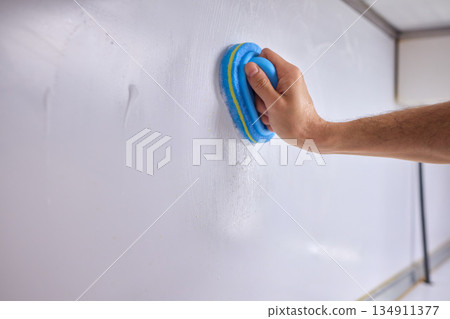 Cleaning the Kitchen Wall effectively with a Sponge and some good detergent for hygiene 134911377