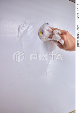 Cleaning the Kitchen Wall effectively with a Sponge and some good detergent for hygiene 134911383