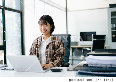 Business woman using tablet and laptop for doing math finance on an office desk, tax, report, accounting, statistics, and analytical research concept in office Business woman using tablet and laptop for doing math finance on an office desk, tax, report, accounting, statistics, and analytical research concept in office 134911641
