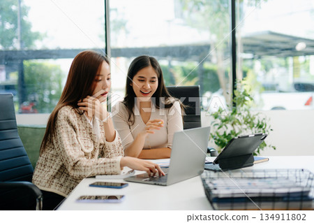 Business portrait two woman asian  smile cheerful talk and holding tablet, computer and hands up happy with in agreement ready new project 134911802