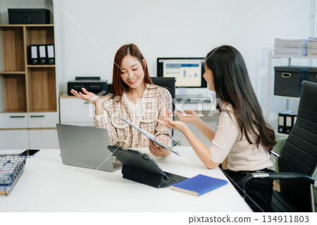 Business team of two executives working together using laptop in office. young asian businesswoman Business team of two executives working together using laptop in office. young asian businesswoman 134911803