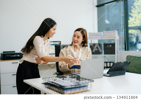 Business team of two executives working together using laptop in office. young asian businesswoman 134911804