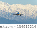 An airplane flying with the Northern Alps in the background 134912214